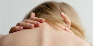 woman holding the back of her neck