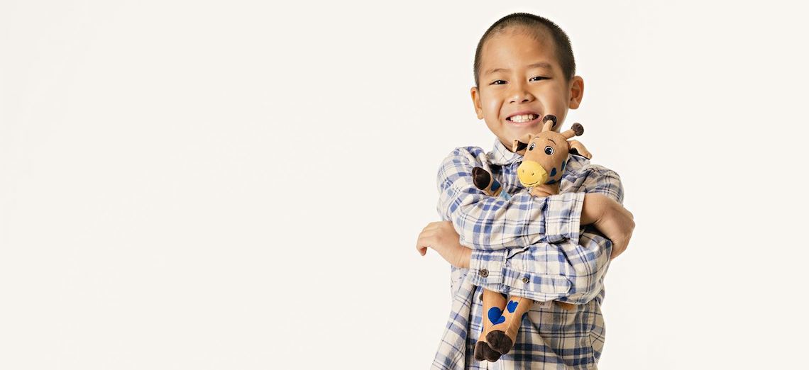 young boy holding stuffed giraffe