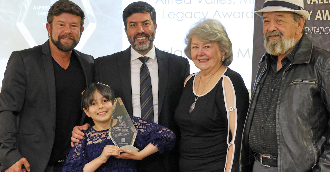 four adults and a child pose for a photo