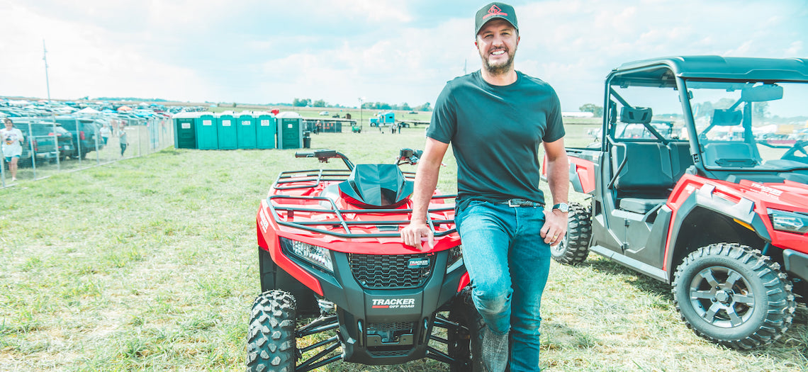 Luke Bryan smiling on an ATV