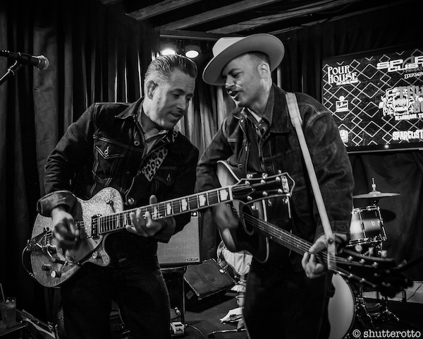 two men playing guitar and singing