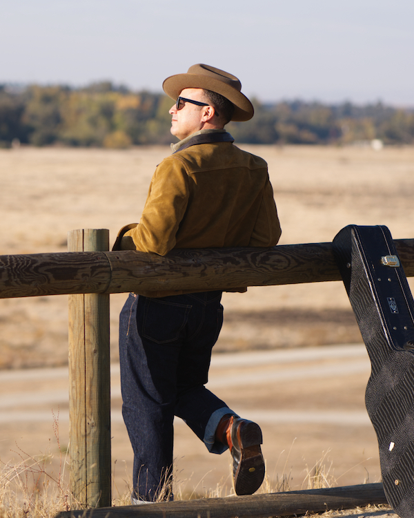 man leaning against a post