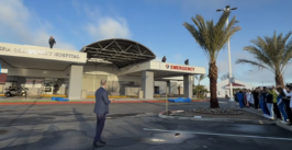 man oversees unveiling of signage on a hospital building