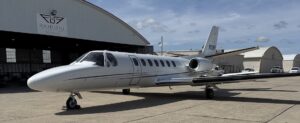 jet parked in front of a hangar