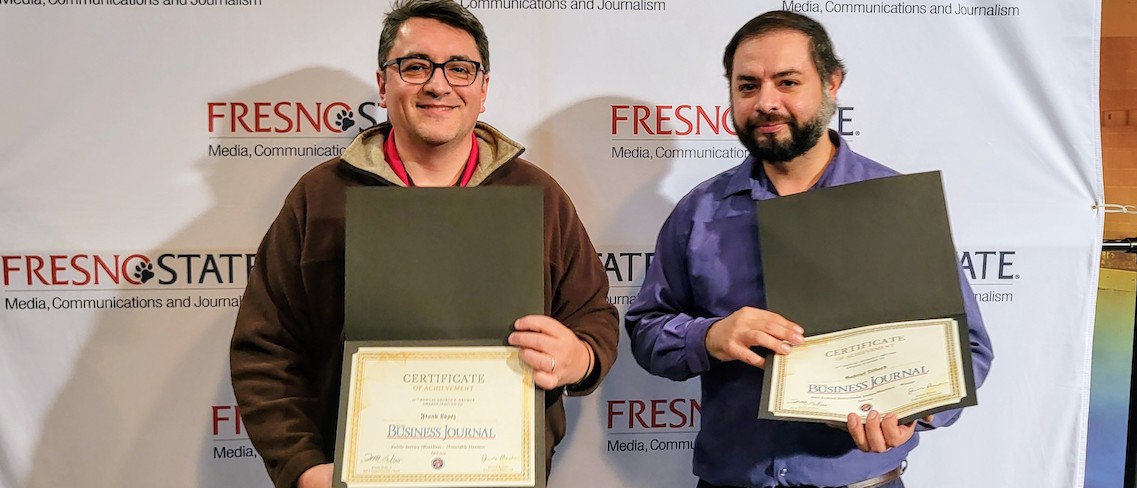 two men holding certificates