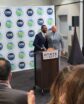 two men behind a podium in front of a crowd