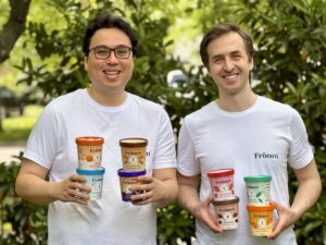 two smiling men holding ice cream cartons