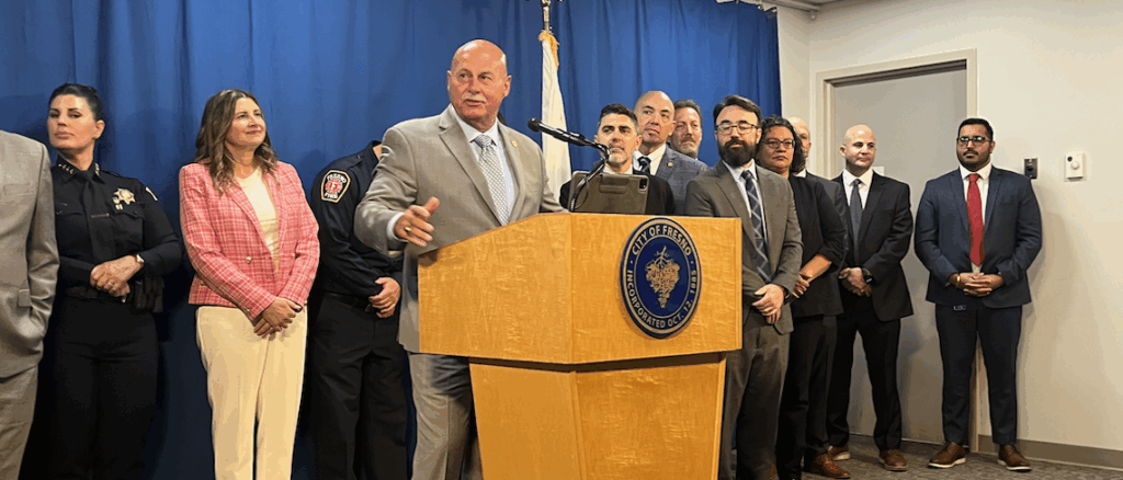 man at podium with people behind him