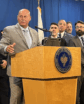man at podium with people behind him