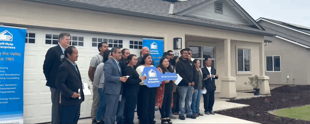 people lined up in front of a house for a photo