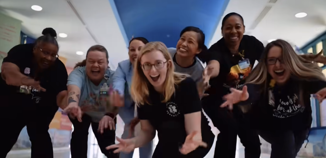 women in front of the camera doing jazz hands