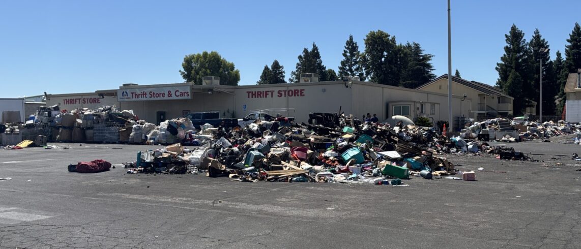 donated items strewn out on a blacktop with building behind