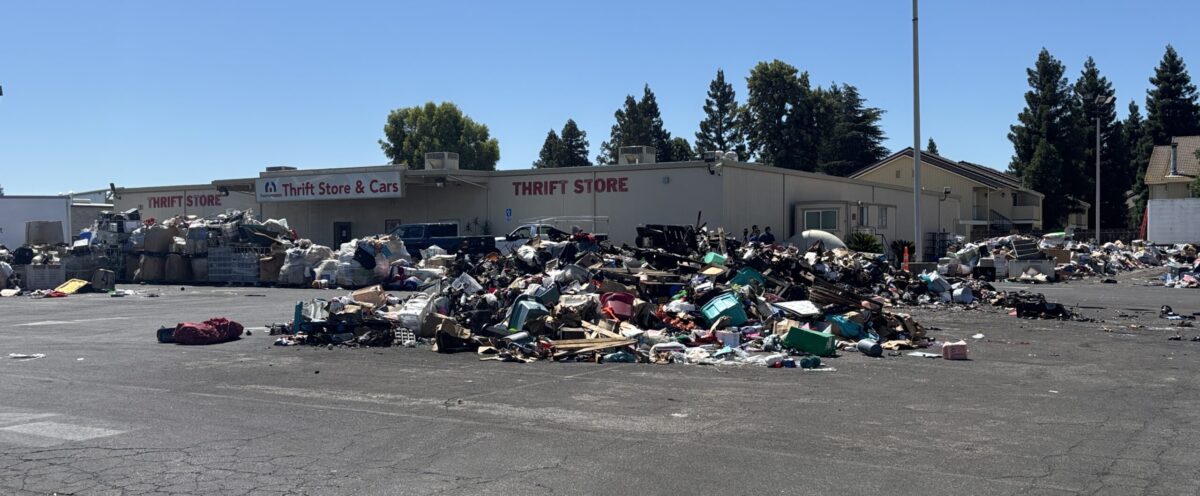 donated items strewn out on a blacktop with building behind