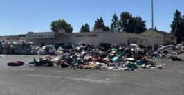 donated items strewn out on a blacktop with building behind
