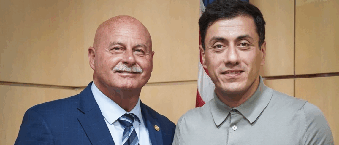 two men pose for a photo