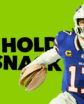 a man holding a pistachio like a football in front of a promotional banner