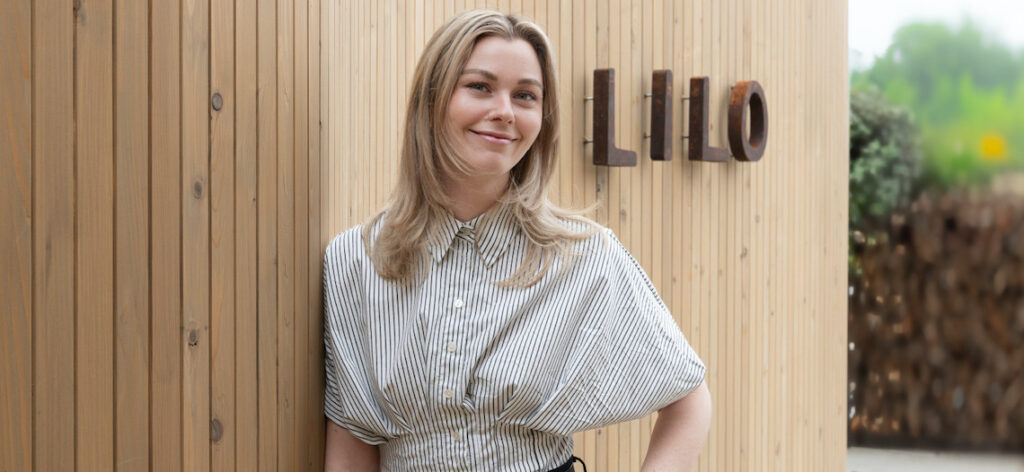 woman standing in front of a sign that says 'lilo'