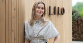 woman standing in front of a sign that says 'lilo'