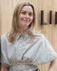 woman standing in front of a sign that says 'lilo'