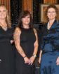 five women standing side by side, posing for a photo