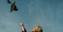 graduation scene where a woman throws a mortar board hat in the air