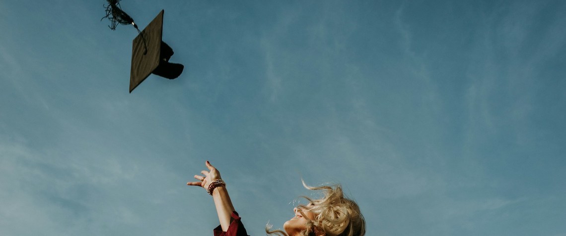 graduation scene where a woman throws a mortar board hat in the air
