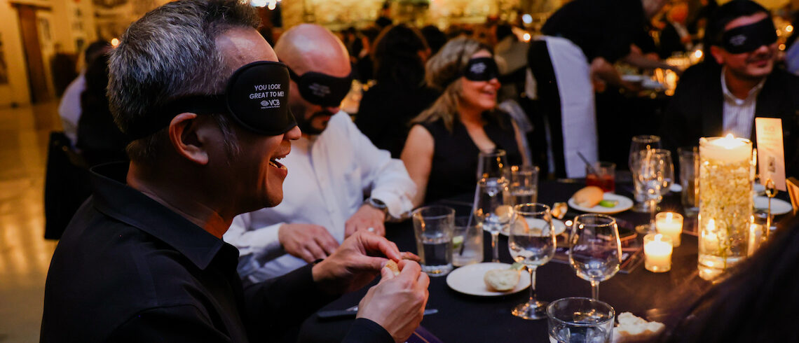 people blindfolded while eating dinner