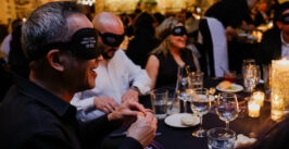 people blindfolded while eating dinner
