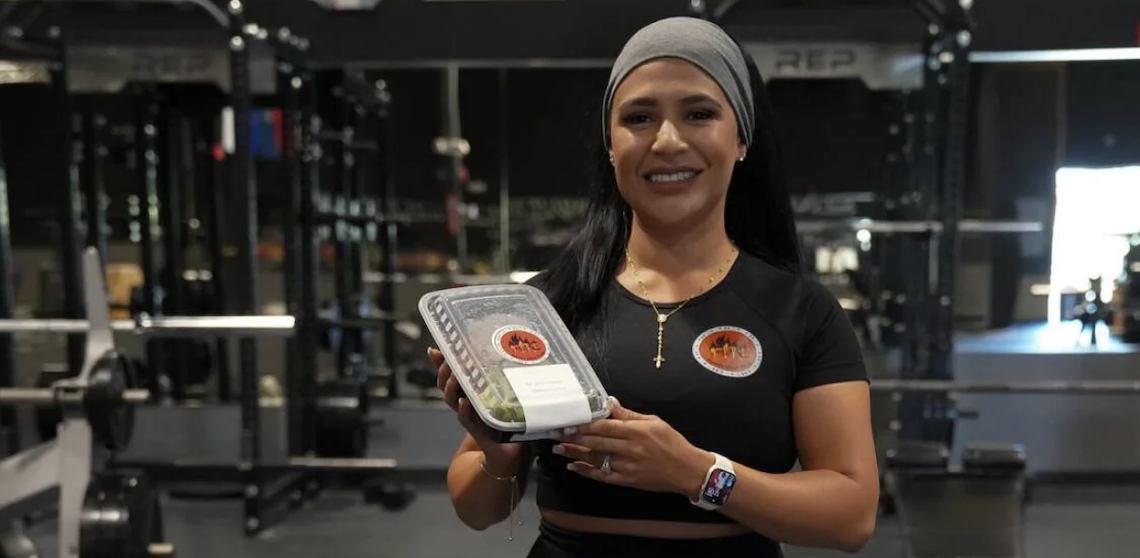 woman holding a container of a prepped meal