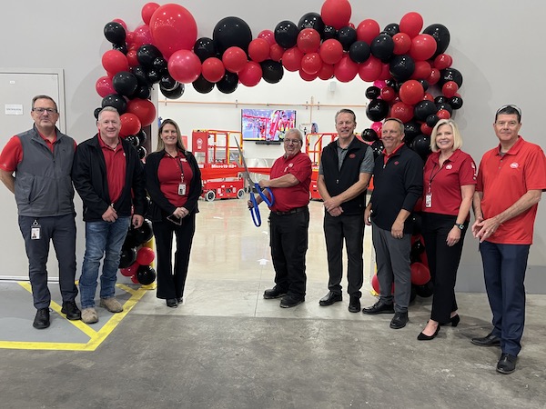 several people gathered for a ribbon cutting with a balloon bridge