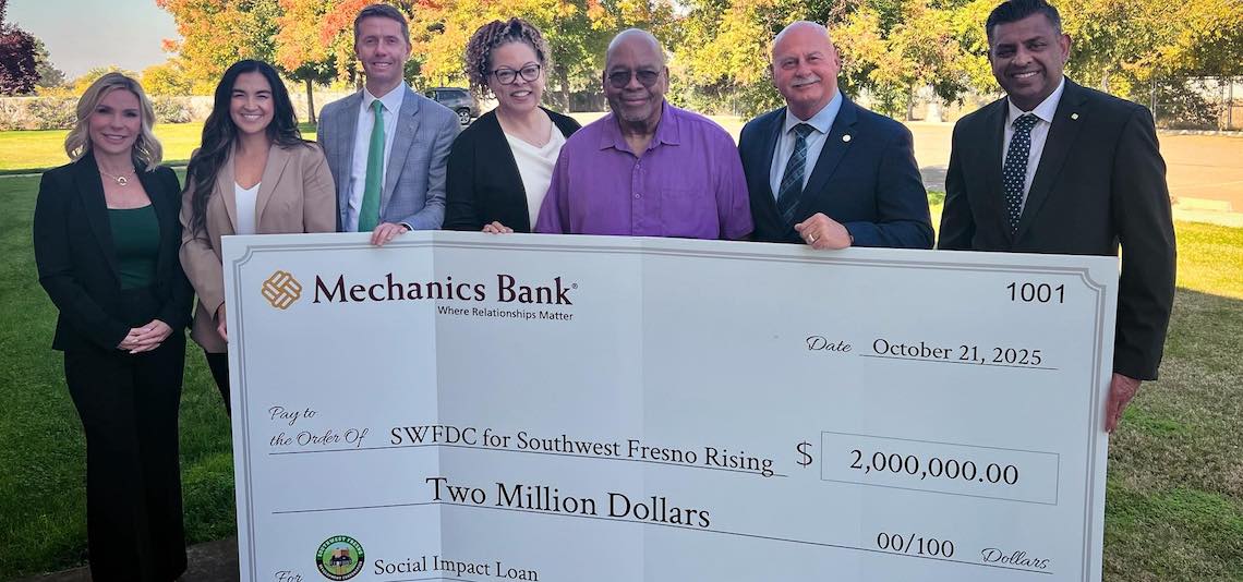 people posing with large $2 million check