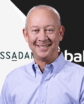 man smiling with two company logos behind him