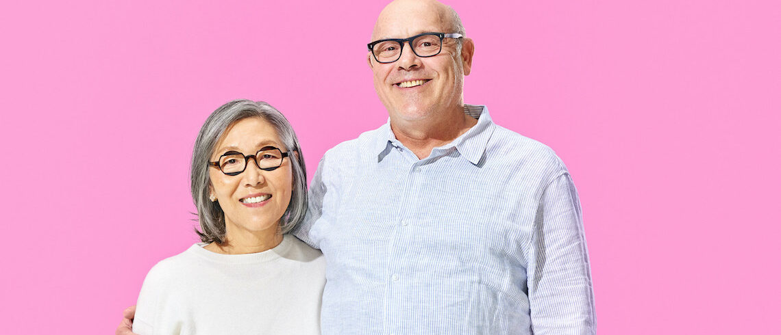 man and a woman against a pink background