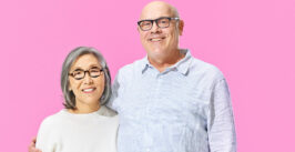 man and a woman against a pink background