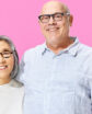 man and a woman against a pink background
