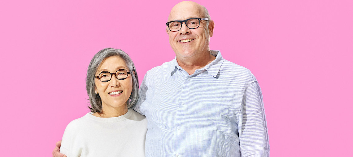 man and a woman against a pink background