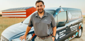 man leaning against a work van