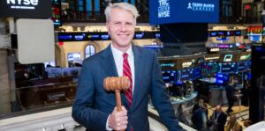 a man holding the gavel to ring the closing bell on wall street's new york stock exchange