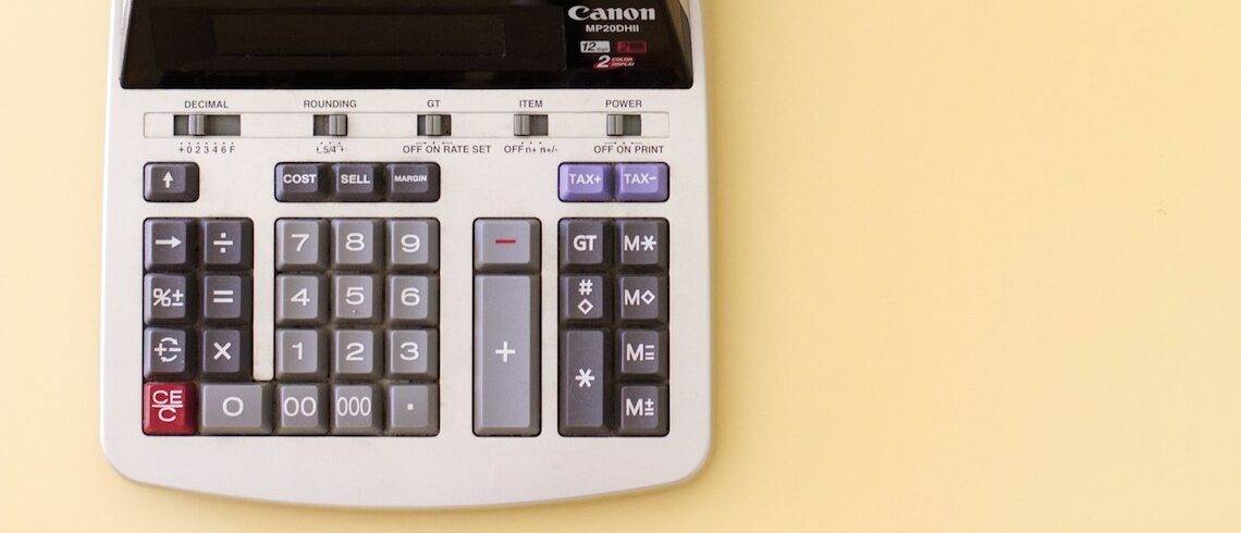 bottom half of a analog calculator against light yellow background