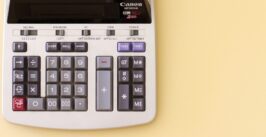 bottom half of a analog calculator against light yellow background