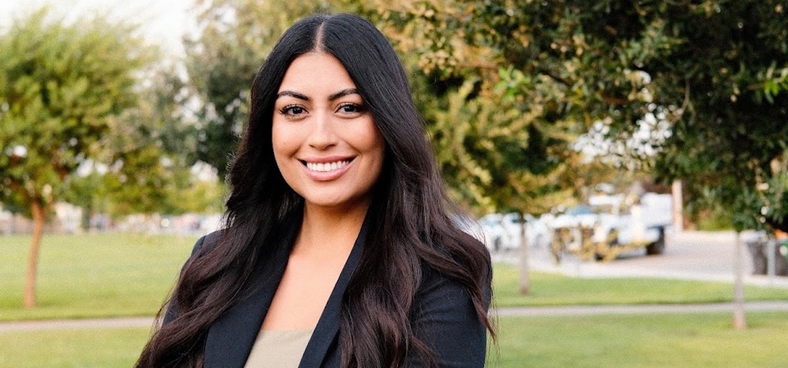 woman smiling with greenery in the background