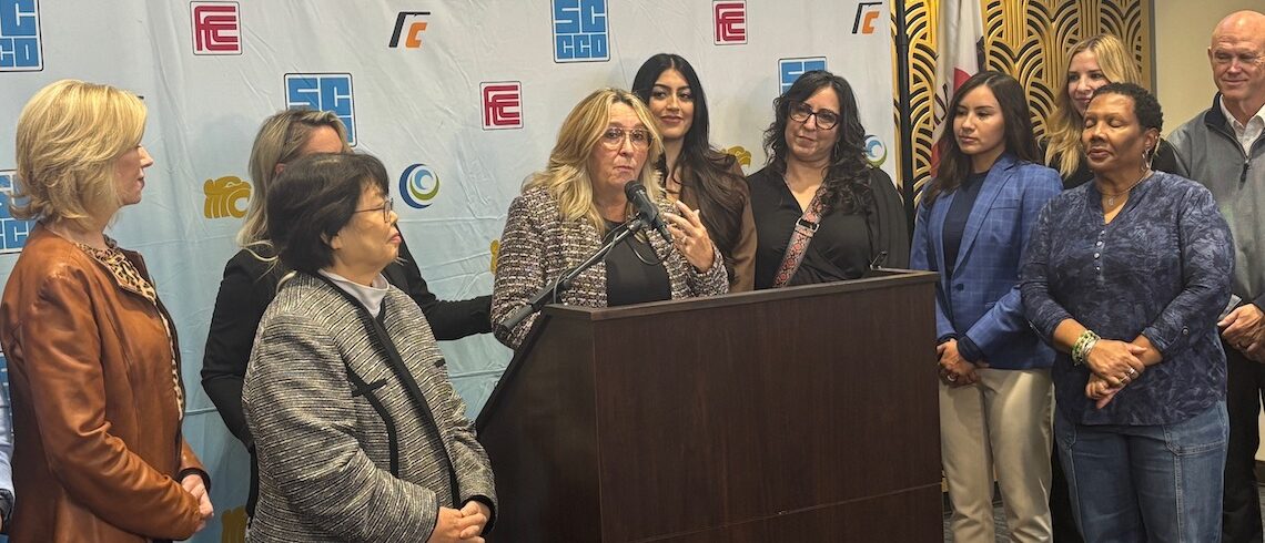 people standing around a woman at a podium