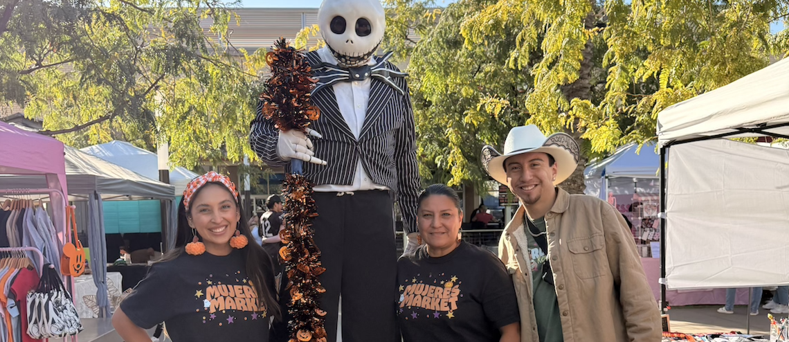 group of people at a vendor fair, and one in a skeleton costume
