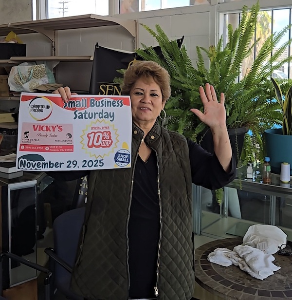 a woman waving and holding a sign