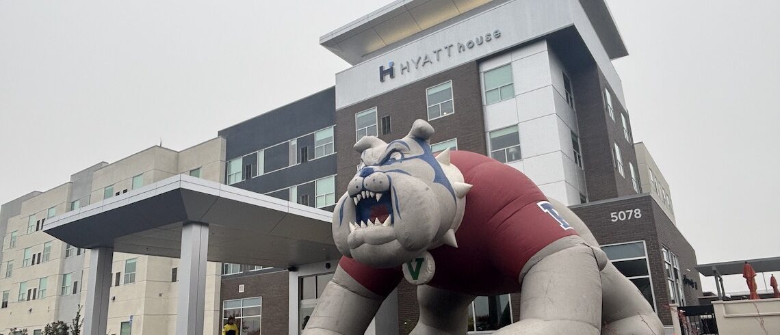 a four-story hotel building with a large inflatable bulldog in front of it