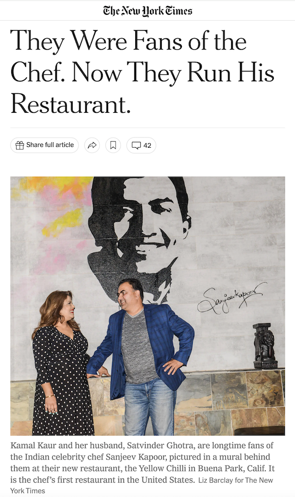 online article with two people standing in front of amural of a man