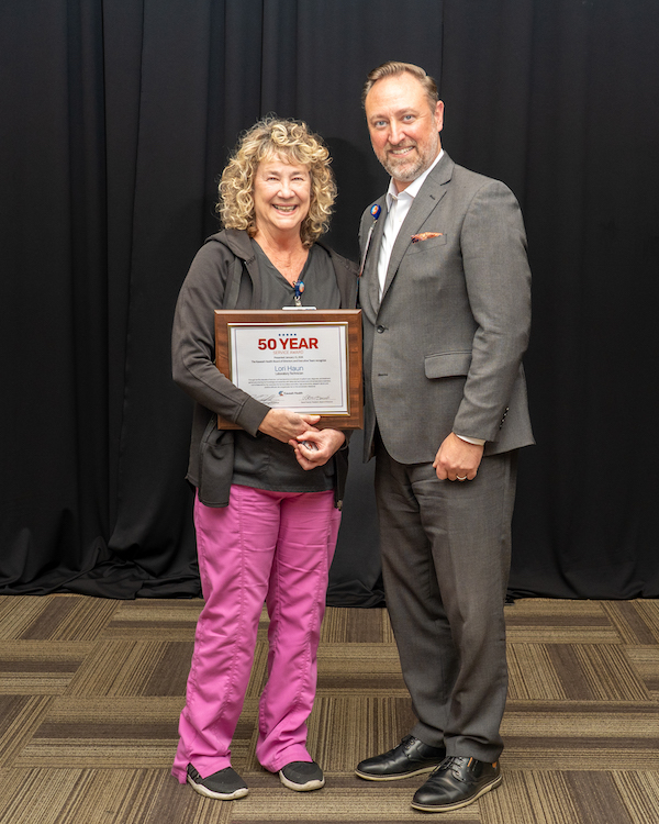 two people standing with a plaque