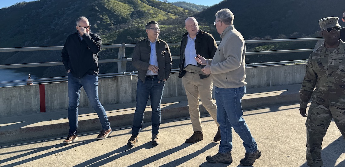 dam tour of five people in business casual attire and an army uniform