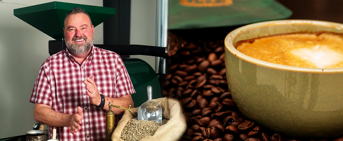 a man grinding coffee beans next to a large cup of coffee