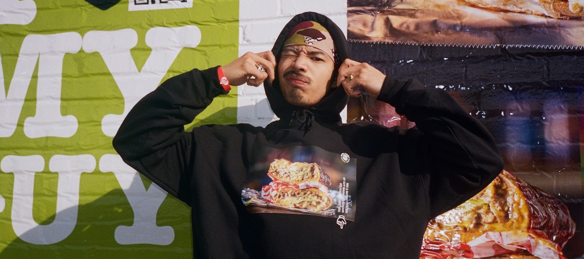 a man pulling the hood of his sweater over his head